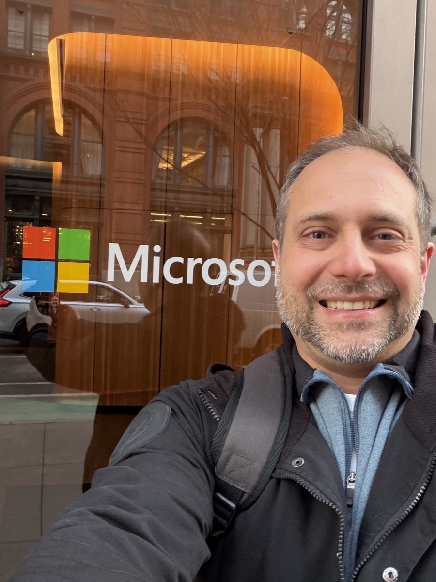 Selfie of Erich Schindler smiling in front of the Microsoft logo at the Microsoft Garage in Manhattan.